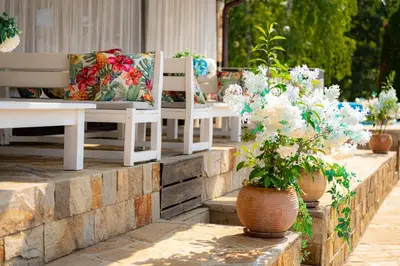 a group of benches with flowers in vases at Ostrova Holiday Village in Beli Osŭm