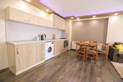 a kitchen and dining room with a table and a kitchen and a room with at Апартамент Радост Сандански in Sandanski