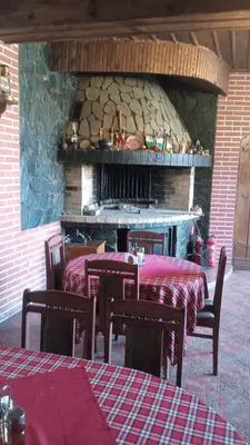 a group of tables and chairs in front of a stone oven at Семеен хотел НАЦИОНАЛ in Mineralni Bani