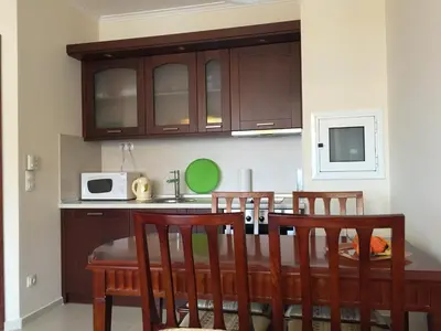 a kitchen with a table with chairs and a microwave at Downtown Alexander Services Apartments in Bansko