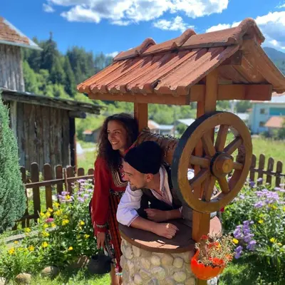 two women are standing next to a wooden bird house at вила Здравец in Yagodina