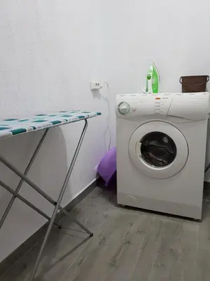 a washing machine with a phone on top of it at United Apartments 2 in Sandanski