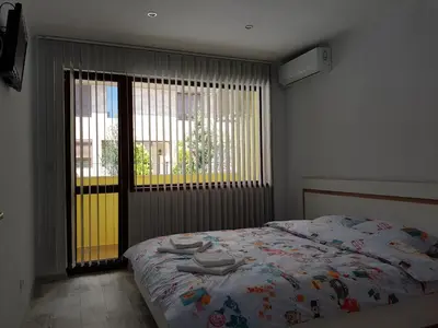 a bedroom with a bed and a large window at United Apartments 2 in Sandanski