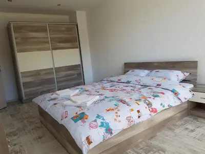 a bedroom with a bed with a wooden headboard at United Apartments 2 in Sandanski