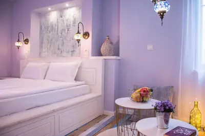a bedroom with a white bed and two tables at SABORNA 25 GUEST HOUSE in Plovdiv