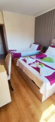 a hotel room with two beds with towels on them at Cedar Lodge 3/4 Apartment Paradise in Bansko