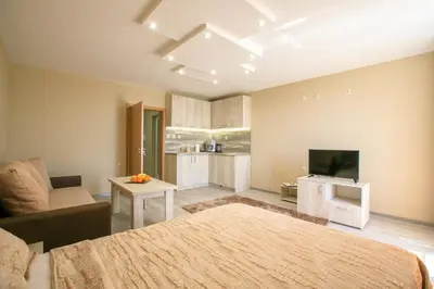 a room with a bed and a couch and a tv at Студиа КРИСИ in Sandanski