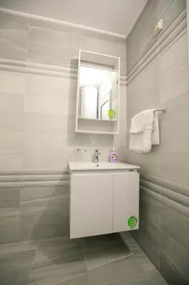 a bathroom with a white sink and a mirror at Студиа КРИСИ in Sandanski