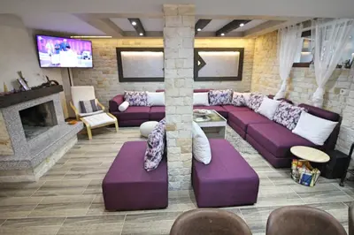 a living room with purple couches and a fireplace at Ice Jewel Chalet, Bansko, 200 meters from the Gondola, 20 улица „Свети Иван Рилски“ in Bansko
