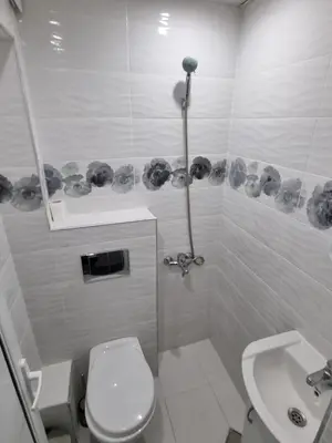 a white bathroom with a toilet and a sink at Motel Thessaloniki in Sandanski