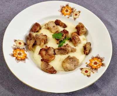 a plate of food with potatoes and gravy at Motel Thessaloniki in Sandanski