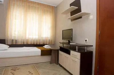 a hotel room with a bed and a television at St.St. Constantine and Helena in Sandanski