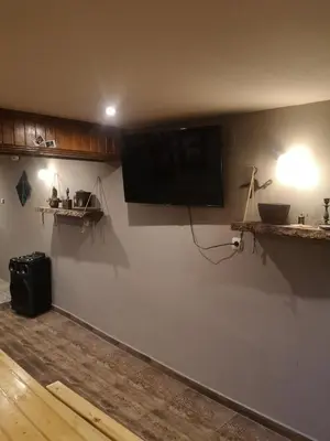 a living room with a flat screen tv on a wall at Къща за гости Romano in Chepelare