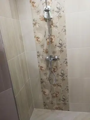 a shower stall with a floral pattern on the wall at Къща за гости Romano in Chepelare