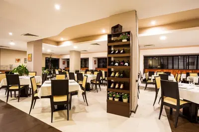 a dining room with white tables and chairs at Hotel Perun Lodge in Bansko