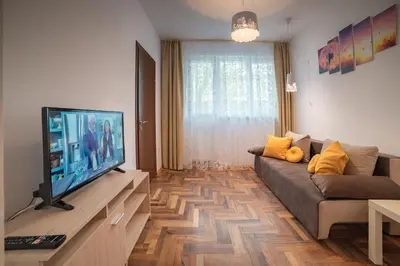a living room with a couch and a flat screen tv at Comfort.Chic.Charming Apt with Terrace near NDK in Sofia