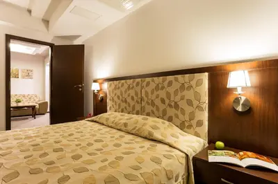 a bedroom with a bed and a book on a desk at Earth & People Hotel & SPA - Free Parking & Swimming Pool in Sofia