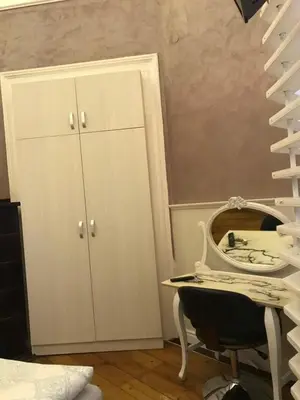 a staircase with a white cabinet and a chair in a room at Come inn - 24h Self Check-in in Sofia