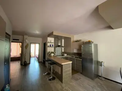 a kitchen with a refrigerator and a table in it at Апартамент Мегилукс in Blagoevgrad