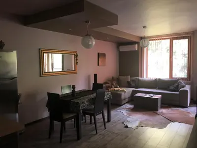 a living room with a couch and a table at Апартамент Мегилукс in Blagoevgrad