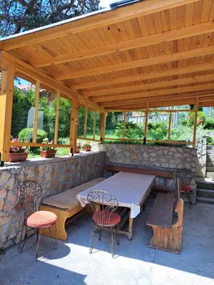 a picnic table and chairs under a wooden pavilion at Vila Katerina in Yundola