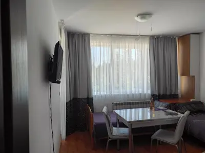 a living room with a table and a couch at IGLIKA 2 SNOWY NIGHT V18 in Borovets