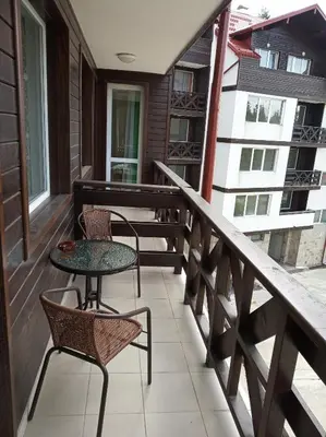 a balcony with two chairs and a table at IGLIKA 2 SNOWY NIGHT V18 in Borovets
