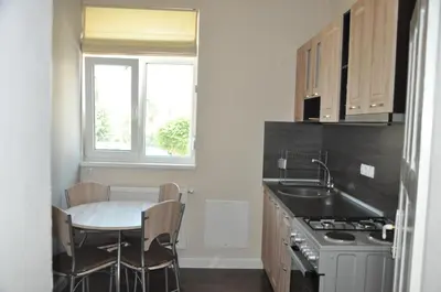 a kitchen with a table and a sink and a window at Къща за гости Ирис in Kyustendil