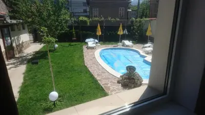 a view of a swimming pool from a window at Къща за гости с минерална вода 