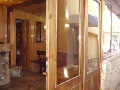 a wooden cabinet with a glass door in a room at Guest House Goranovi in Velingrad