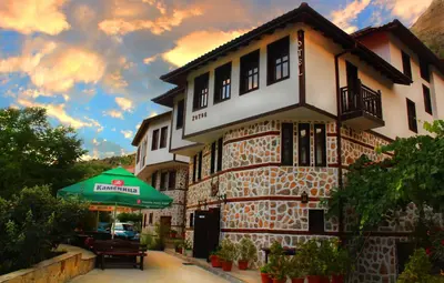 a building with a green umbrella in front of it at Hotel Slavova Krepost in Melnik