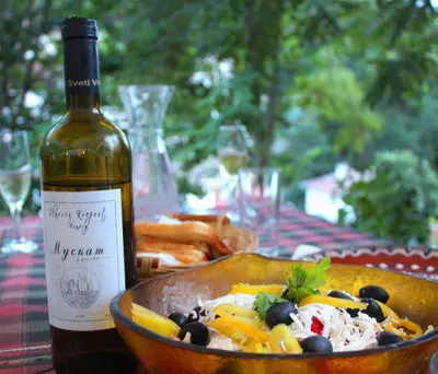 a bottle of wine sitting next to a bowl of food at Hotel Slavova Krepost in Melnik