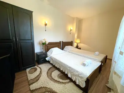 a bedroom with two beds and a rug at Hotel Slavova Krepost in Melnik