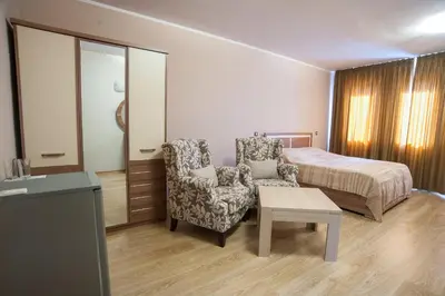 a bedroom with a bed and a chair and a table at C Comfort Hotel & Wellness in Hisarya