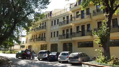a yellow building with cars parked in front of it at C Comfort Hotel & Wellness in Hisarya