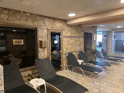 a waiting room with chairs and a stone wall at Hotel Panorama Velingrad in Velingrad