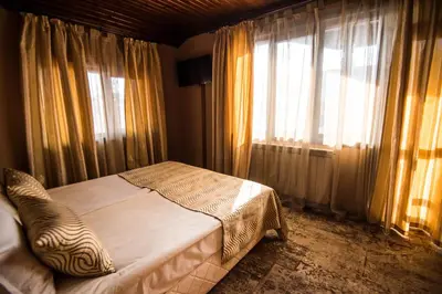 a bedroom with a bed and a large window at Elida Family Hotel in Bansko