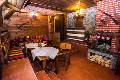 a dining room with a table and chairs and a fireplace at Elida Family Hotel in Bansko