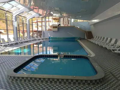 a large swimming pool with chairs in a building at хотел Чифлика - комплекс Чифлика in Chiflik