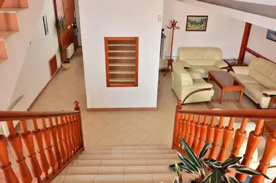 a room with a staircase with a couch and chairs at Family Hotel LILI in Bansko