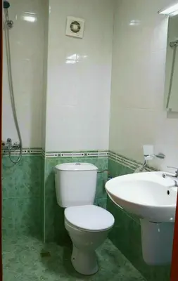 a bathroom with a toilet and a sink at Family Hotel LILI in Bansko