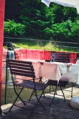 a table and a chair with a table cloth on it at Zlatna ribka in Kokolyane