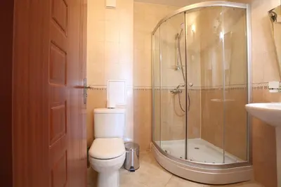 a bathroom with a shower and a toilet and a sink at Guest House Ela in Bansko