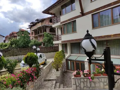 a street light in front of a building with flowers at Guest House Ela in Bansko