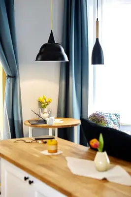 a kitchen with a wooden table with blue curtains at Courthouse Apartments Slavi in Sofia