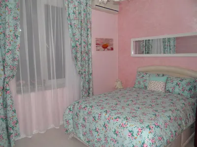a bedroom with a bed and a pink wall at Orange Flower Apartments in Sofia
