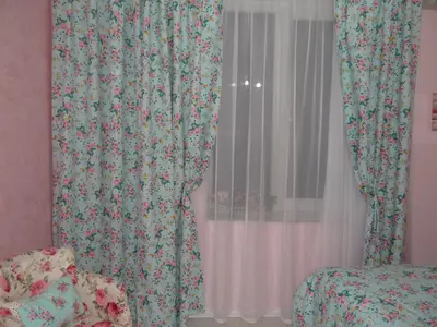 a bedroom with a window with a floral curtain at Orange Flower Apartments in Sofia