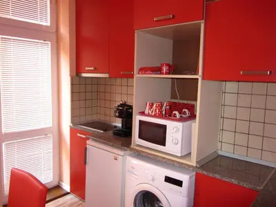 a kitchen with a washing machine and a microwave at Orange Flower Apartments in Sofia