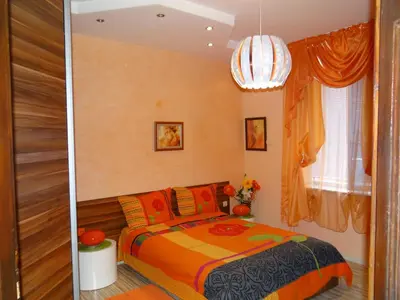 a bedroom with a bed with an orange blanket at Orange Flower Apartments in Sofia