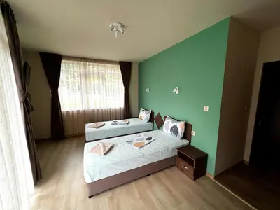 a bedroom with two beds and a green wall at Villa Galiana in Simitli
